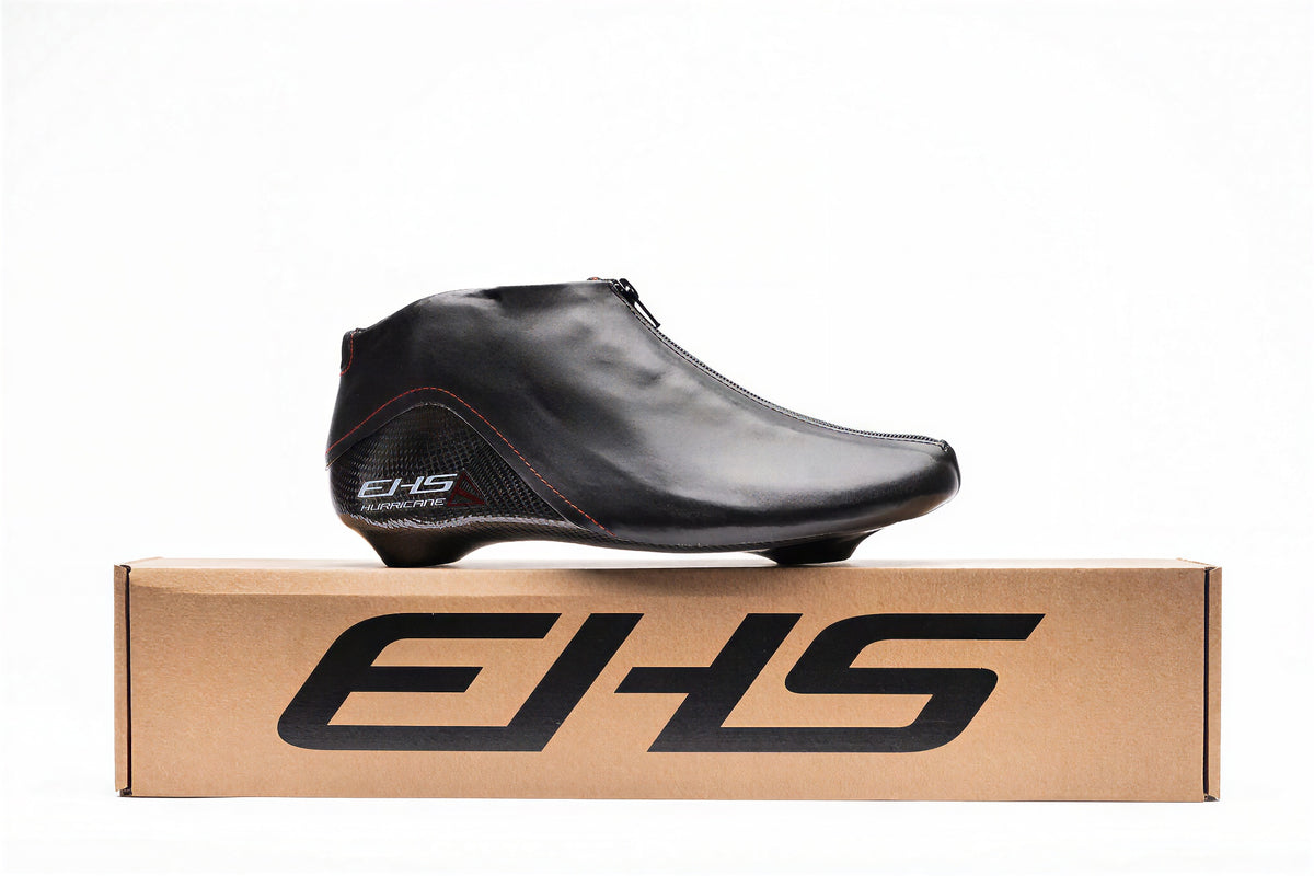 Hurricane long track boot, black, standing on a cardboard EHS box