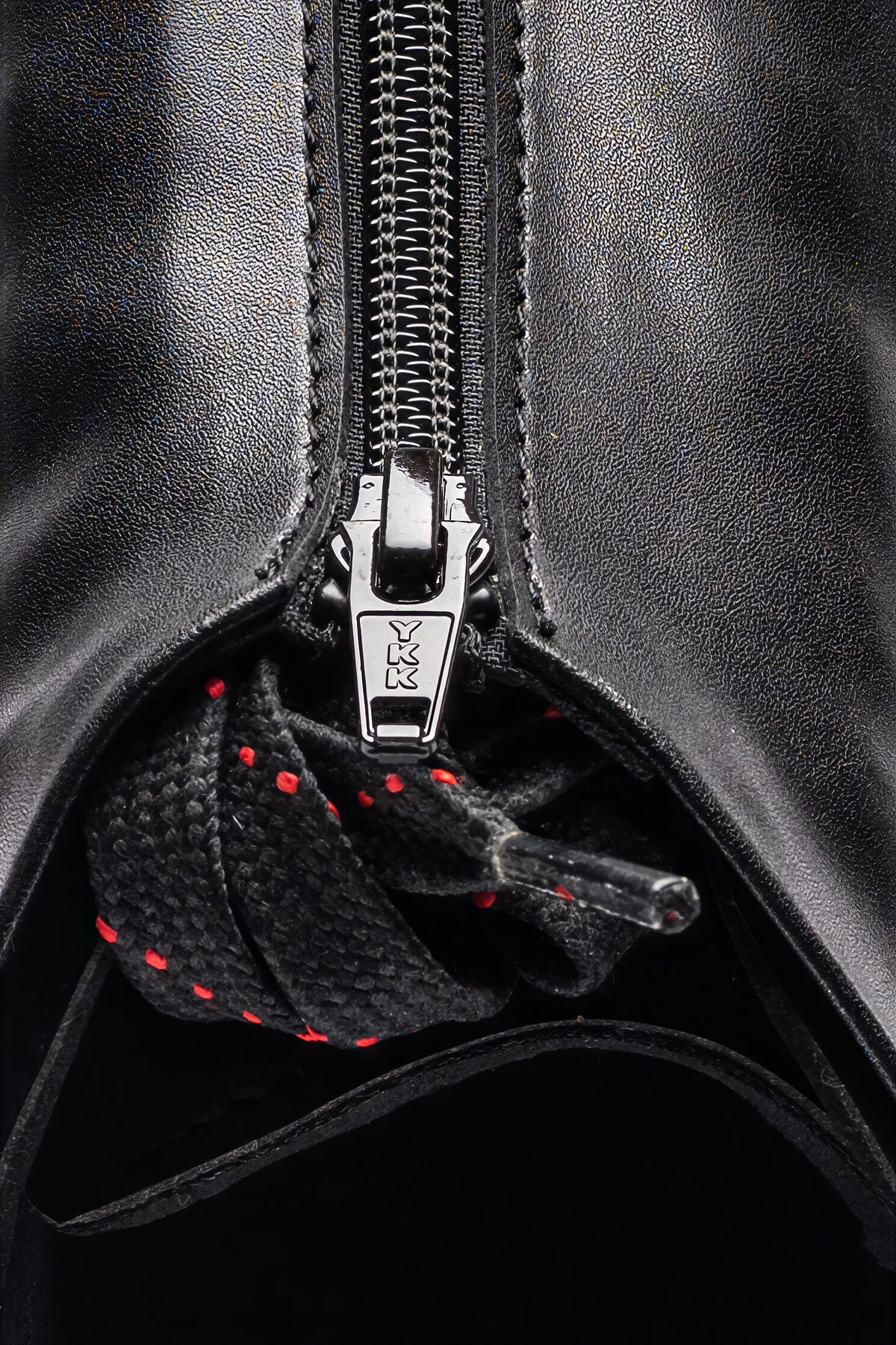 Hurricane long track boot, black, macro of YKK zipper pull and dotted laces