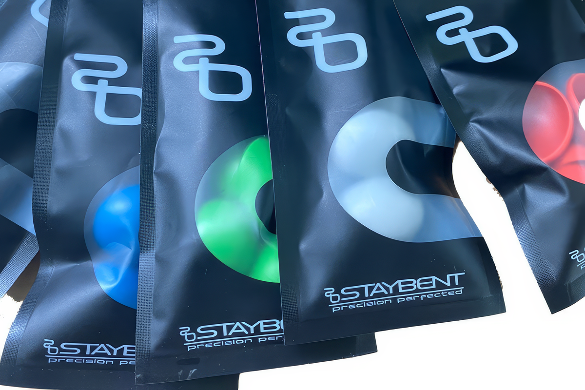 StayBent 塑料指尖护套，StayBent 包装，透过窗口可见蓝、绿、白、红色护套