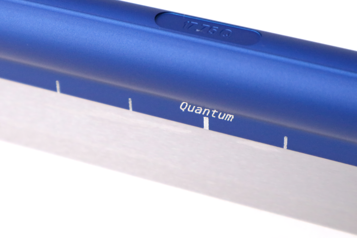 StayBent Quantum short track speed skate blade, close-up of the Quantum mark on the blue tube